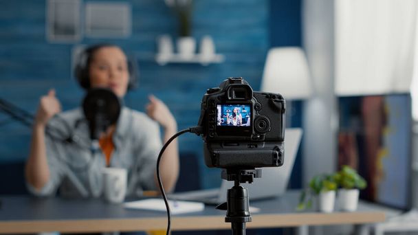視聴者と話してプロのカメラ録画vloggerの撮影を閉じます。ホームスタジオデスクに座っている間、インターネットビデオ共有プラットフォームのための有名なソーシャルメディアインフルエンサーの撮影vlog. - 写真・画像