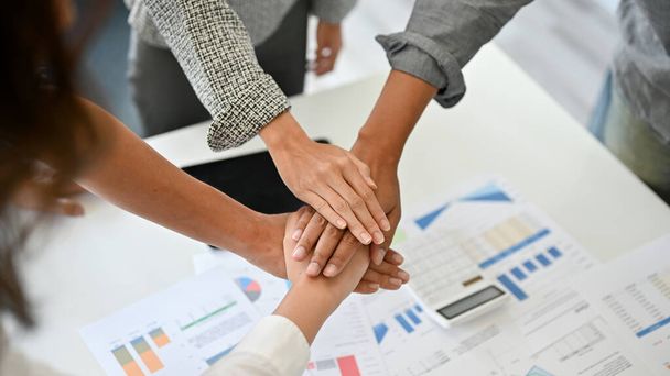 Eine Unternehmensgruppe, die ihre Hände über dem Besprechungstisch zusammenlegt. Unity Business Teamwork-Konzept - Foto, Bild