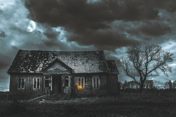 Eski ahşap ev, gece dramatik bulutlar. Terk Edilmiş Korku Evi. Geceleri yanında ayı olan bir ağaç var.. - Fotoğraf, Görsel