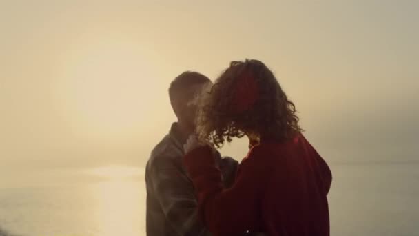Leikkisä nainen ja mies tanssivat rannalla auringonnousun aikaan. Romanttinen pari halaamassa meren rannalla. Onnellinen tyttö ja mies ilmaisevat tunteita toisilleen. Nuoret rakastavaiset viettää aikaa yhdessä. Elämäntapakäsite - Materiaali, video
