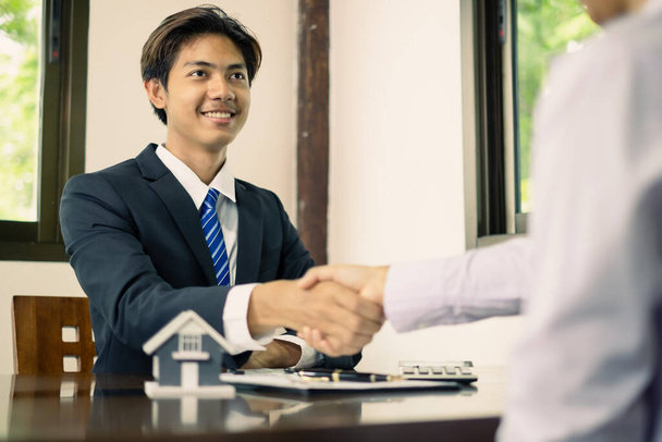 Businessmen and brokers real estate agents shake hands after completing negotiations to buy house insurance and sign contracts. home insurance concept. - Photo, Image