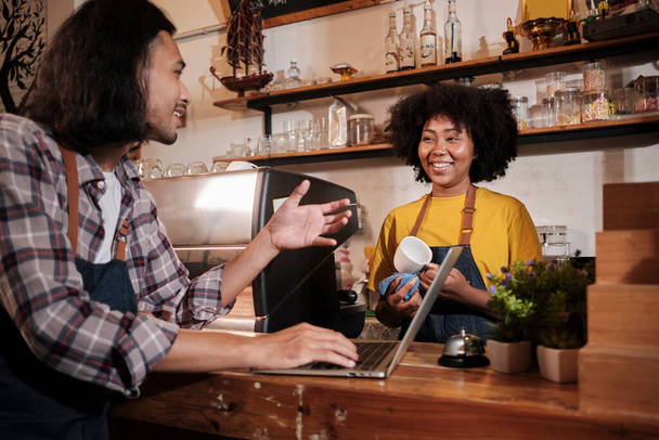 Két kávézó üzleti startup partnerek és barátok, afro-amerikai nő, és a thai férfi baristák beszélni és vidám mosoly együtt pult bár kávézó, boldog szolgáltatás munkát, és a kkv-vállalkozó. - Fotó, kép