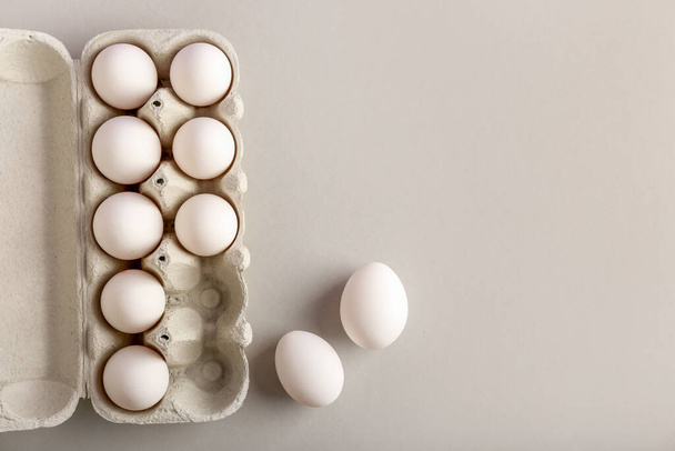 Тримач картону з сирими курячими яйцями на світлому фоні
 - Фото, зображення