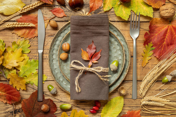Herfst rustieke tafelschikking tussen bladeren en bessen op vintage houten tafelblad uitzicht. Thanksgiving, Halloween of oogstconcept - Foto, afbeelding