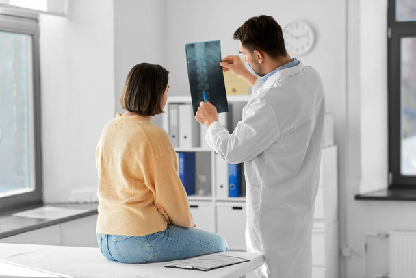 medicine, healthcare and people concept - male doctor showing x-ray to female patient at medical office in hospital - Zdjęcie, obraz