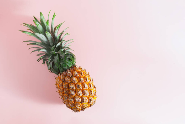 fresh pineapple seasonal tropical fruit on a pink background - Foto, Bild