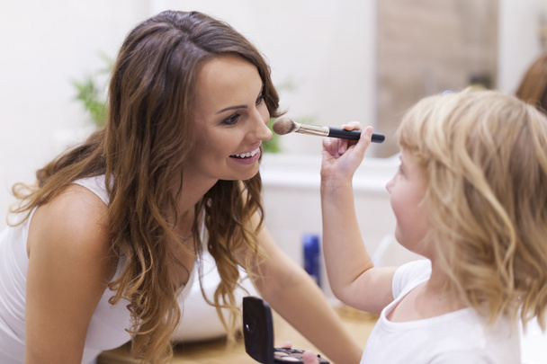Mother playing make-up with daughter - Foto, afbeelding