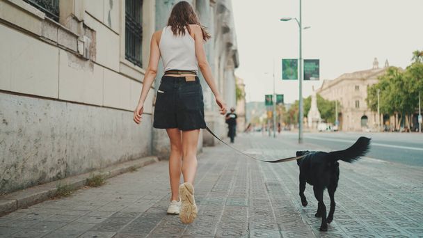 Girl walks down the city street with her pet.  - Photo, image