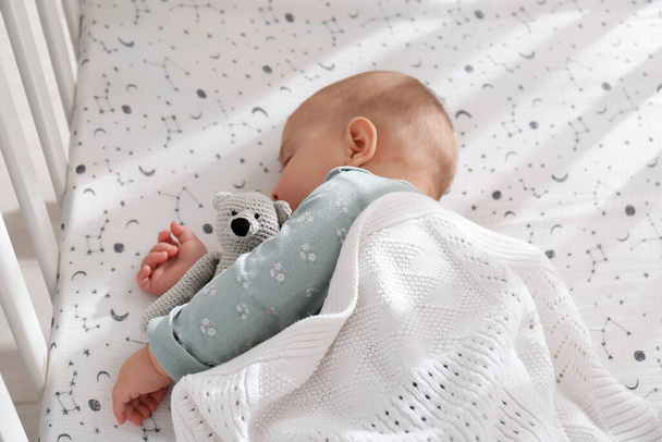 Adorable baby with toy peacefully sleeping in crib - Fotoğraf, Görsel