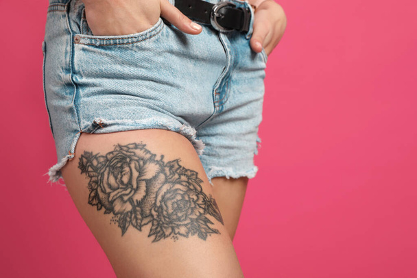 Woman with tattoo on leg against pink background, closeup. Space for text - Foto, Imagem