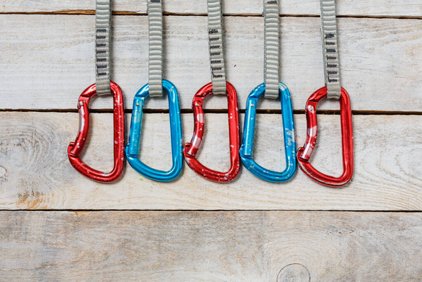 Set of climbing quickdraws on a wooden background. Rock climbing equipment - Foto, Imagem