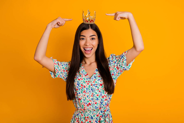 Photo of young cheerful egocentric female showing her luxurious royal crown diadem isolated on yellow color background. - Fotografie, Obrázek