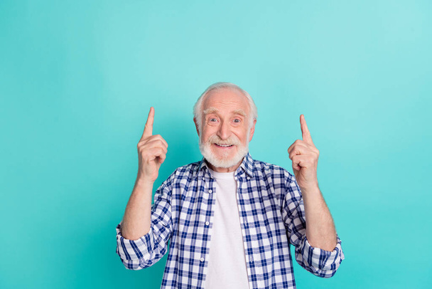 Photo of handsome cheerful grandfather promoting product point fingers blank space isolated on teal color background. - Фото, изображение