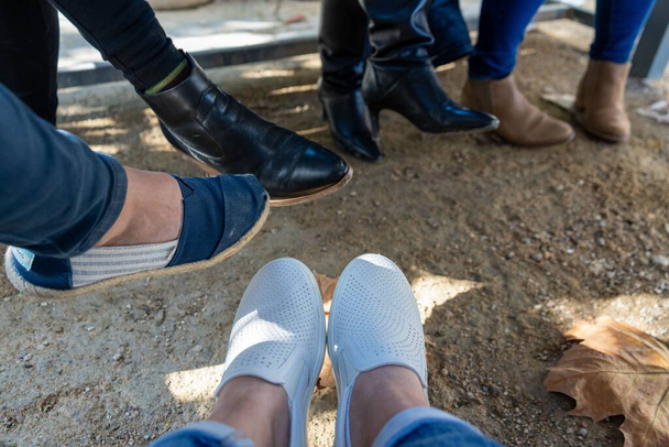 A closeup shot of people's feet in shoes outdoors - Photo, Image