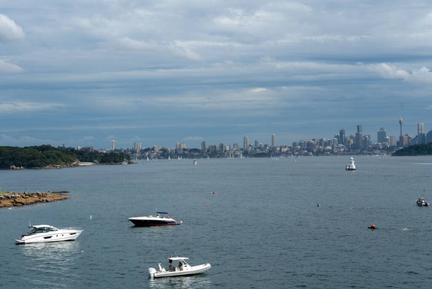 A high angle shot of boats sailing in a blue sea against cityscape in Australia - Zdjęcie, obraz