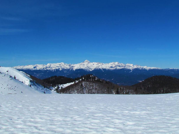 Vista de la cumbre de la montaña Triglav y las montañas circundantes en los Alpes Julianos, Gorenjska, Eslovenia en invierno tomada de Ratitovec - Foto, Imagen