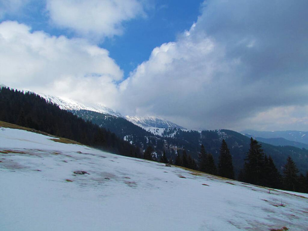 Malowniczy widok zimowy na górę Kladivo w Karavanke, Słowenia pokryta chmurami ze stokami pokrytymi śniegiem - Zdjęcie, obraz