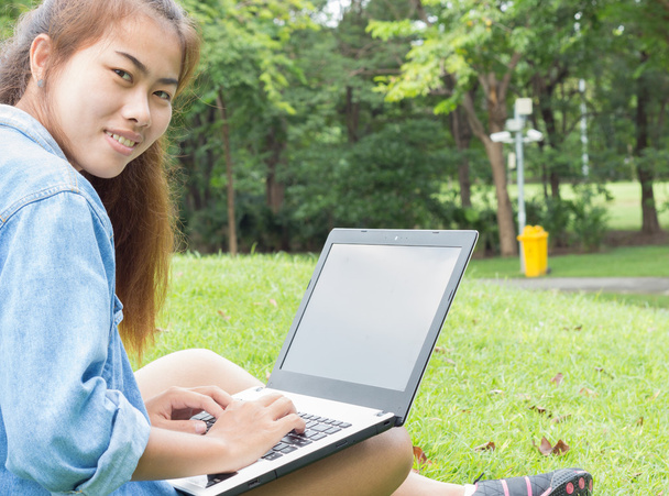 Glimlach vrouw gebruik laptopcomputer in het park - Foto, afbeelding