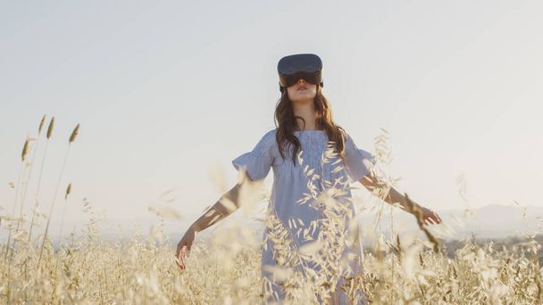 A virtuális valóság szemüveges lány a futurisztikus természetet nézi. Kézi felvétel. - Fotó, kép