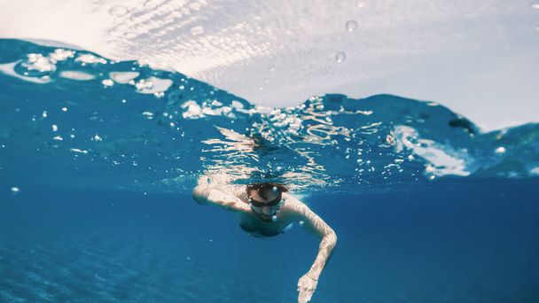 Çocuk açık okyanusta serbest yüzüyor. Su altı çekimi. - Fotoğraf, Görsel