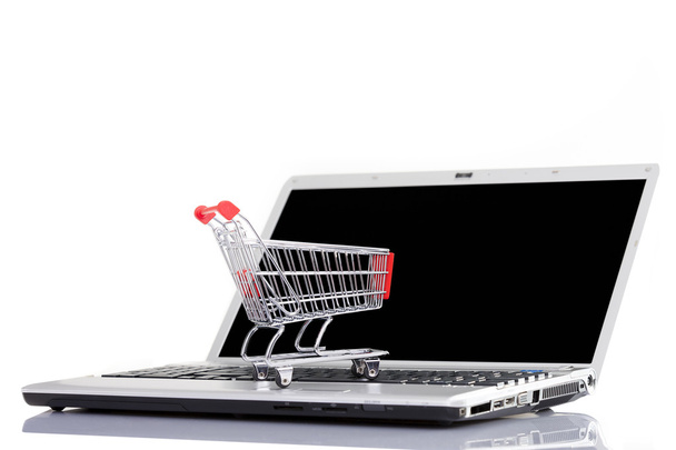Carro de la compra sobre un ordenador portátil, aislado sobre fondo blanco
 - Foto, imagen