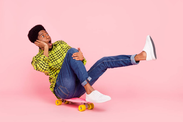 Full body photo of amazed excited afro american man ride longboard speed copyspace isolated on pink color background. - Fotografie, Obrázek