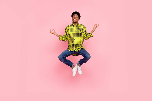 Full size photo of young cool brunette guy jump wear shirt jeans sneakers isolated on pink background. - Zdjęcie, obraz