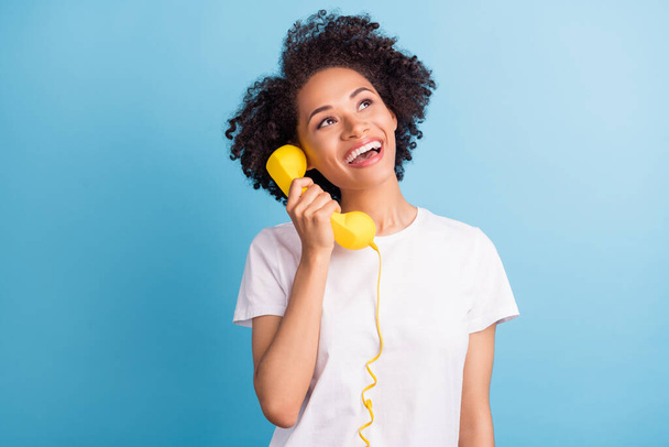 Photo of cheerful excited smiling african girl look copyspace dreaming talk on phone isolated on blue color background. - Valokuva, kuva
