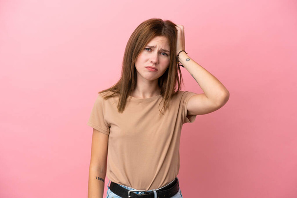 Jonge Engelse vrouw geïsoleerd op roze achtergrond met een uitdrukking van frustratie en niet begrijpen - Foto, afbeelding