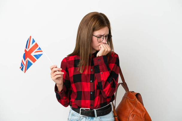 İngiltere bayrağını taşıyan genç bir kadın mavi arka planda izole edilmiş şüpheleri var. - Fotoğraf, Görsel