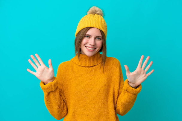 Nuori englantilainen nainen yllään talvitakki eristetty sinisellä taustalla laskenta kymmenen sormilla - Valokuva, kuva