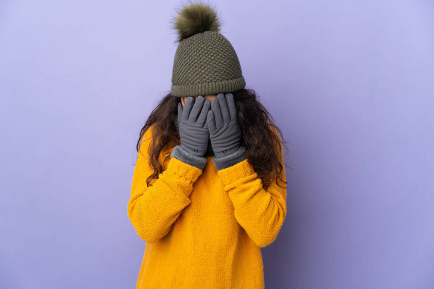 Teenager Russian girl with winter hat isolated on purple background with tired and sick expression - Fotó, kép