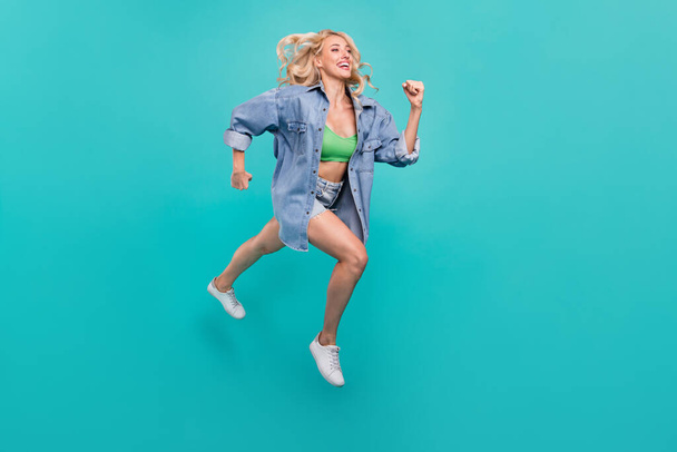 Full size photo of happy cheerful positive woman jump up run empty space isolated on blue color background. - Photo, Image