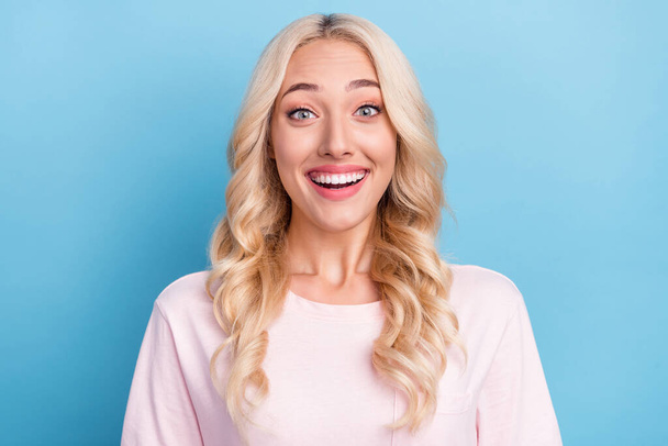Photo portrait blonde woman curly hair smiling happy staring amazed isolated pastel blue color background. - 写真・画像