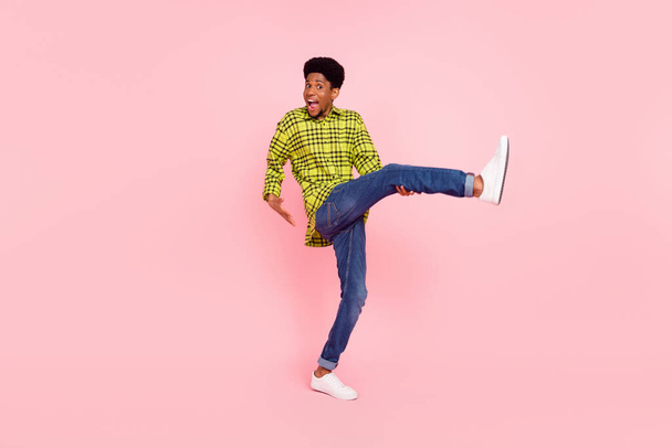 Full size photo of positive happy afro american man raise leg good mood isolated on pink color background. - Fotó, kép
