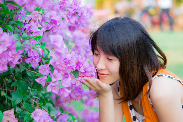 Cute Thai girl scent a purple Kertas. She loves flowers. - Foto, imagen