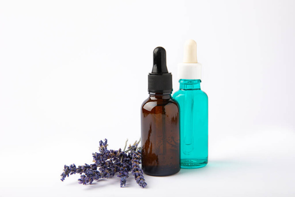 Lavender essential oil in glass bottle with pipette.Bottle with fragrant oil and lavender flowers isolated on white background.mockup of lavender essential oil with copy space.serum. - Photo, Image