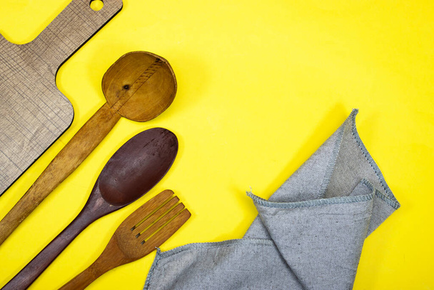 Various cooking utensils spoon with wooden cutting board, napkin - Fotografie, Obrázek