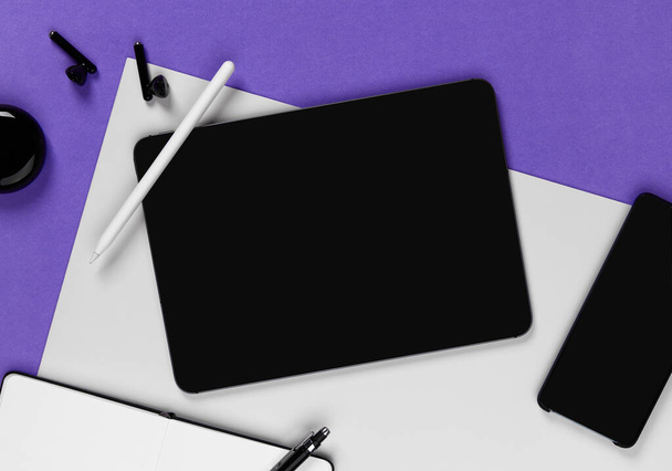 Flat lay top view blank screen digital tablet on violet background. Home office workspace. Business work template. - 写真・画像