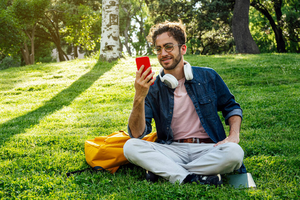Portrait extérieur de beau jeune homme hipster avec téléphone portable
. - Photo, image