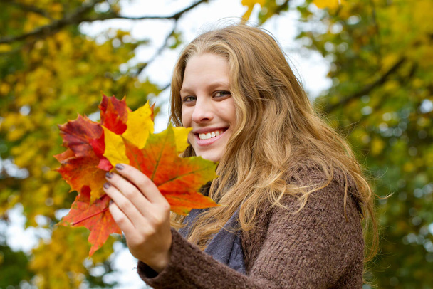 Счастливая молодая женщина осенью - Фото, изображение