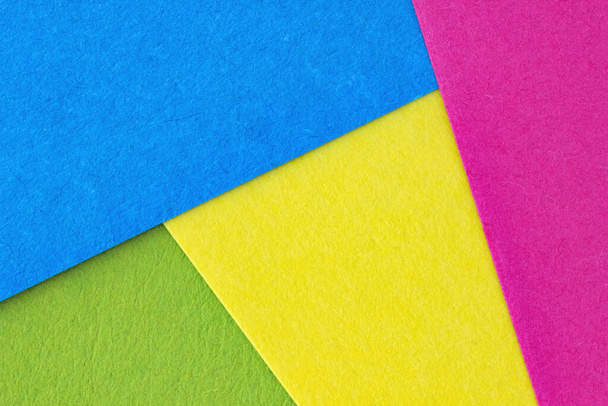 Photo abstraite de la composition du papier bleu, vert, rose, jaune. Lumineux fond coloré de feuilles de papier. - Photo, image