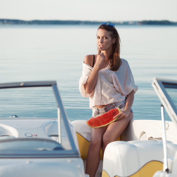 Pretty young girl with watermelon posing on a yacht - Фото, зображення