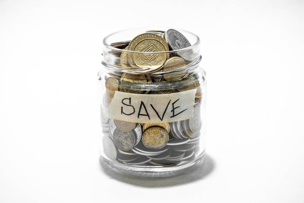 Heldere glazen pot voor tips met munten geld geïsoleerd op wit. Financieel concept - Foto, afbeelding