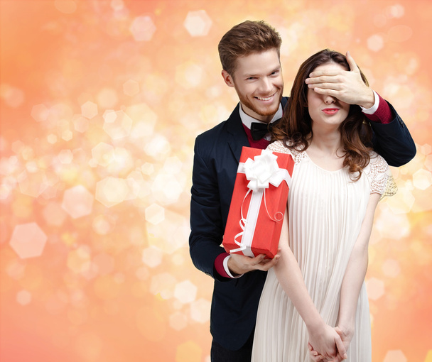 Подарить подарок на Рождество мужчина закрывает глаза своей девушке
 - Фото, изображение