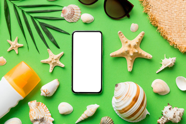 Flat lay composition with Phone and beach accessories on colored background. Smartphone with blank screen mock up with copy space. - Foto, Bild