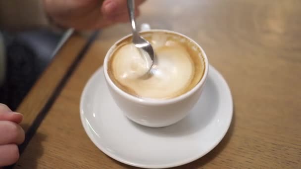 Ręka kobiety wylewa cukier i miesza kawę łyżeczką, czas na kawę. - Materiał filmowy, wideo
