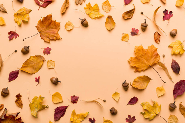 Jesienny skład z suszonych liści, szyszek i żołędzi na stole. Płaskie ułożenie, widok z góry. - Zdjęcie, obraz