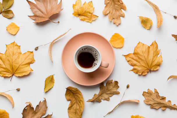 Composition de plat laïc avec tasse colorée d'automne de café et de feuilles sur un fond de couleur. vue de dessus. - Photo, image