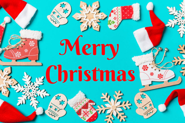 Merry Christmas text. Top view of Christmas decorations and Santa hats on blue background. Happy holiday concept with copy space. - 写真・画像